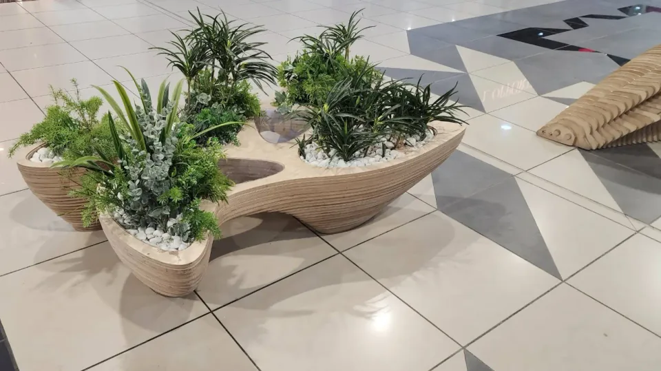 Rain gatherer table, planted Rain Gatherer table installed in a bright public interior.